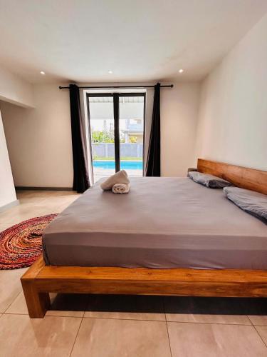 a large bed in a room with a large window at Luxurious 3 Bedroom Villa with Private Pool - NG1 in Arsenal