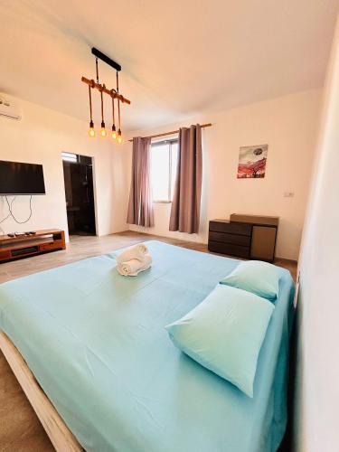 a bedroom with a large blue bed with two pillows at Luxurious 3 Bedroom Villa with Private Pool - NG1 in Arsenal