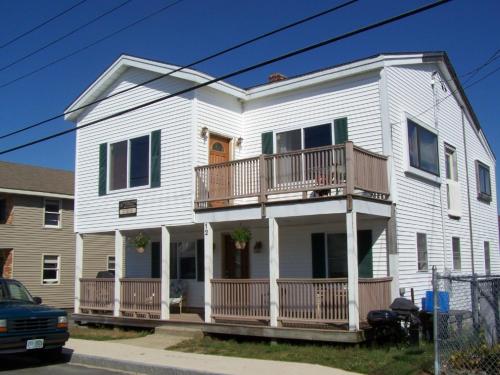 a white house with a balcony on a street at Nautical Beach Properties in Hampton