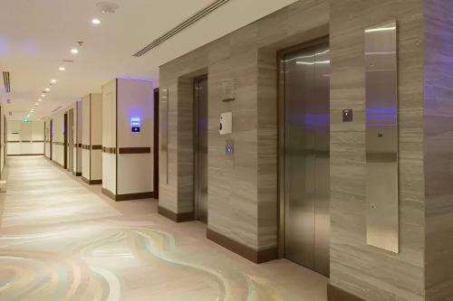 a row of elevators in a building with a hallway at Comfort Hotel Jeddah King Road in Jeddah