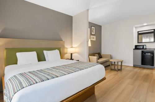 a bedroom with a large bed and a living room at Country Inn & Suites by Radisson, Roanoke, VA in Roanoke