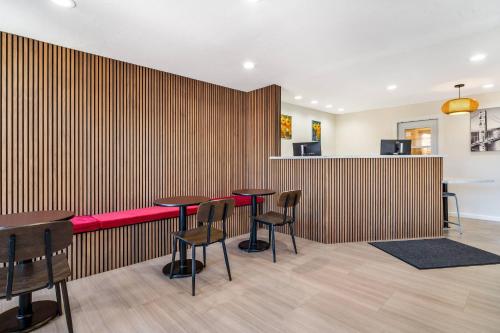a restaurant with tables and chairs against a wooden wall at La Luna Inn, an Ascend Collection Hotel in San Francisco
