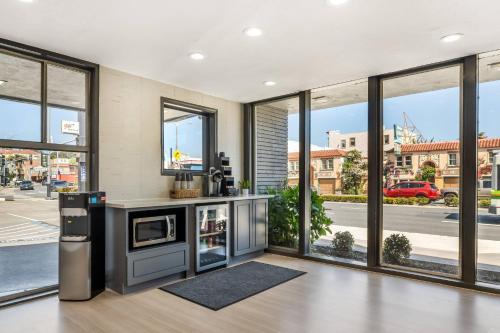 a living room with large windows and a kitchen at La Luna Inn, an Ascend Collection Hotel in San Francisco
