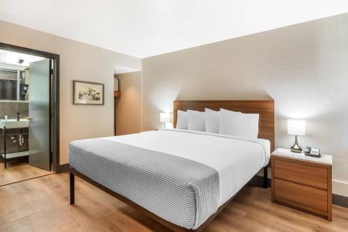 a bedroom with a large bed and a bathroom at La Luna Inn, an Ascend Collection Hotel in San Francisco