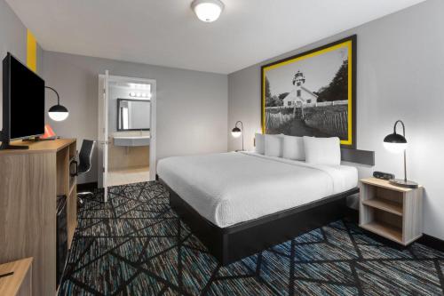 a hotel room with a bed and a flat screen tv at Super 8 by Wyndham Traverse City in Traverse City