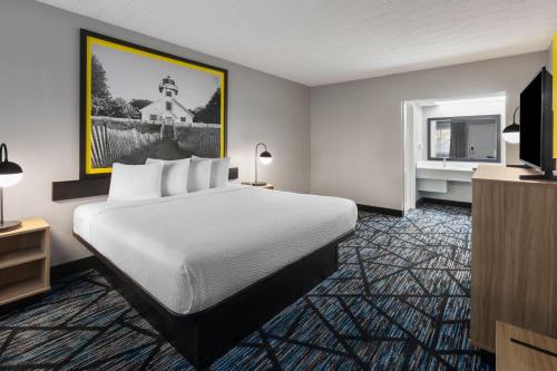 a hotel room with a bed and a television at Super 8 by Wyndham Traverse City in Traverse City