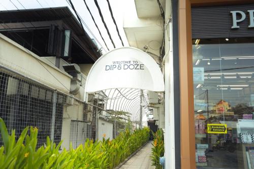 a sign for the entrance to a dip dye store at Dip & Doze Living in Canggu