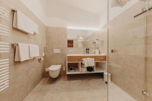 a bathroom with a toilet and a sink and a shower at Habachklause Familien Bauernhof Resort in Bramberg am Wildkogel