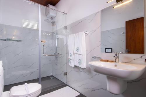 a white bathroom with a sink and a shower at Mr & Mrs K's Villa- Kandy in Kandy