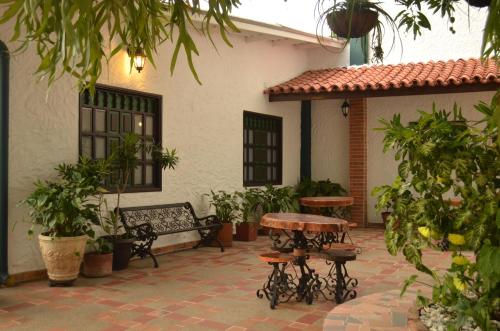 a patio with a table and benches in front of a house at Hotel El Virrey Boutique Honda in Honda