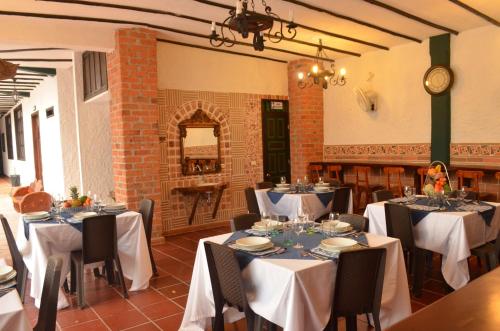 a dining room with tables with white tablecloths at Hotel El Virrey Boutique Honda in Honda