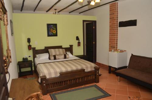 a bedroom with a bed and a couch at Hotel El Virrey Boutique Honda in Honda