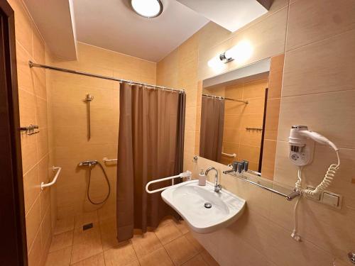 a bathroom with a sink and a shower at Pensjonat Szach in Krynica Zdrój
