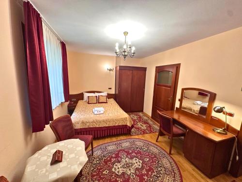 a room with a bedroom with a desk and a bed at Pensjonat Szach in Krynica Zdrój
