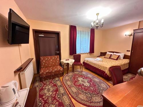 a hotel room with a bed and a television at Pensjonat Szach in Krynica Zdrój