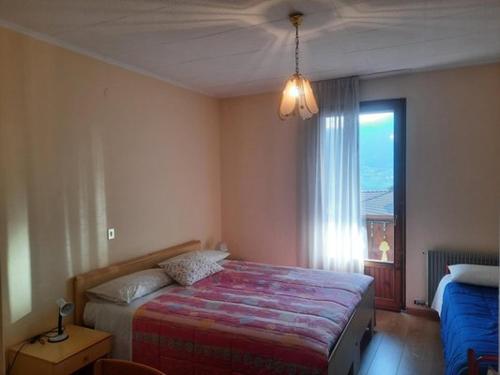 a bedroom with a large bed and a window at AlpinaBnB in Castello Tesino