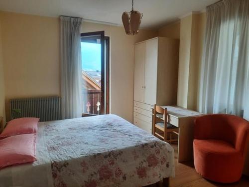 a bedroom with a bed and a desk and a chair at AlpinaBnB in Castello Tesino
