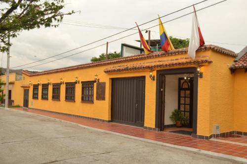 a yellow building with flags on top of it at Hotel El Virrey Boutique Honda in Honda