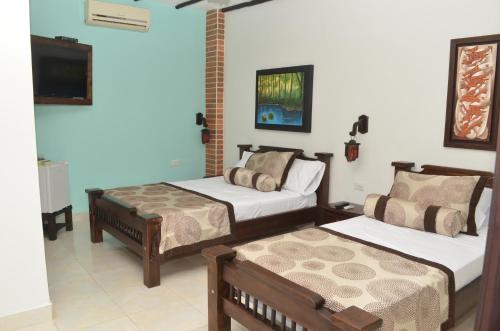 a bedroom with two beds and a tv in it at Hotel El Virrey Boutique Honda in Honda