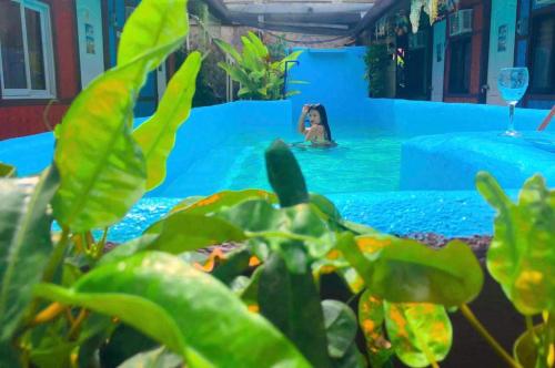 a woman in a swimming pool with a person in the water at Mama Hostel & Guest House in El Nido