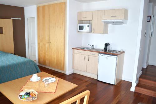 a small kitchen with a table in a room at Hôtel la Scala in Pithiviers