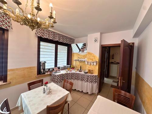 a dining room with a table and chairs and a chandelier at Pensjonat Szach in Krynica Zdrój