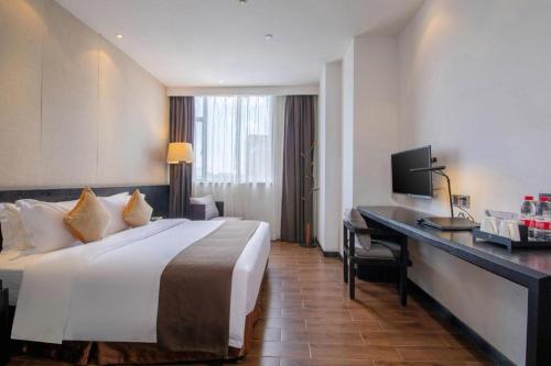 a hotel room with a large bed and a desk at H Life Hotel Nanshan Branch in Shenzhen