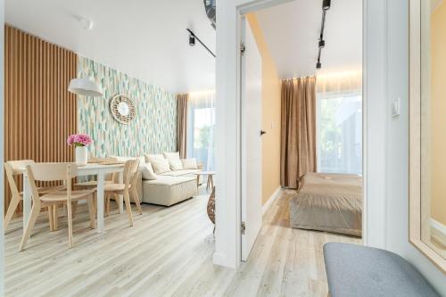 un salon avec une table et une chambre dans l'établissement Apartament Let's Sea z Basenem by BALTIC CLUB, à Gąski