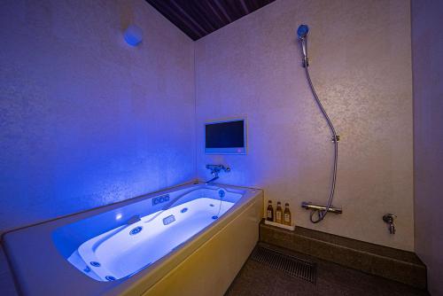 een badkamer met een groot bad en een douche bij HOTEL FIVE plus -Adult Only- in Osaka