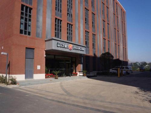 a large red brick building with a sign on it at Jinjiang Inn Select Shanghai International Tourism and Resorts Zone Chuansha Road Subway Station in Shanghai