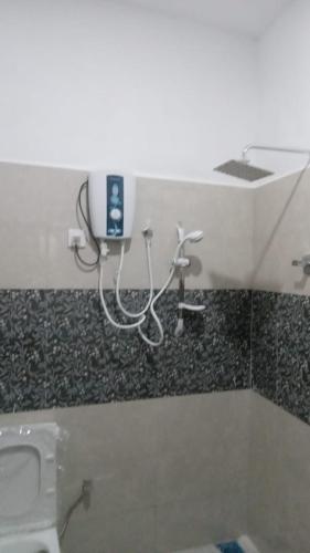 a bathroom with a toilet and a soap dispenser on the wall at Rooms in matara in Matara