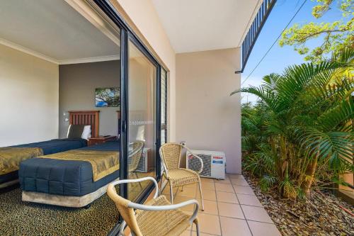 a bedroom with a bed and chairs on a balcony at Comfort Inn Grafton in Grafton