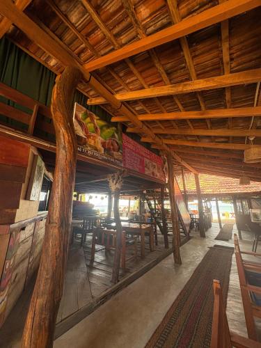 ein Restaurant mit Holzdecken und Tischen und Stühlen in der Unterkunft Nilaveli Sheen Coast in Trincomalee