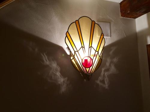 a light on a wall with a lamp on a ceiling at L'ESCALE DE CAMILLE in Murat