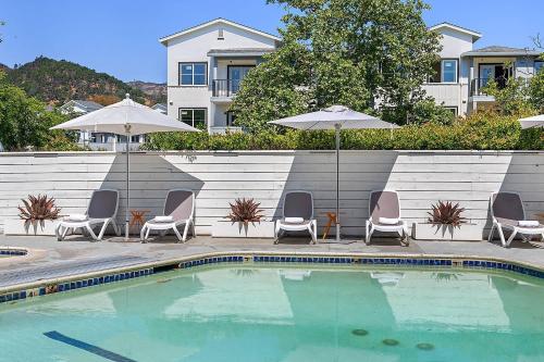 a pool with chairs and umbrellas next to a building at UpValley Inn & Hot Springs, an Ascend Collection Hotel in Calistoga