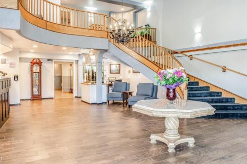 a living room with a staircase and a table with flowers on it at Clarion Hotel By Humboldt Bay in Eureka