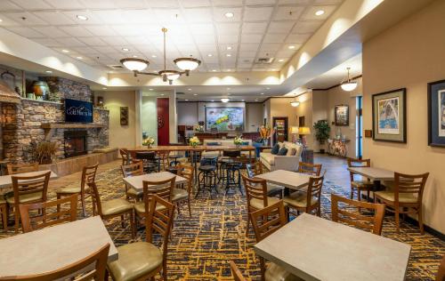 a restaurant with tables and chairs and a fireplace at Gold Miners Inn Grass Valley, an Ascend Collection Hotel in Grass Valley