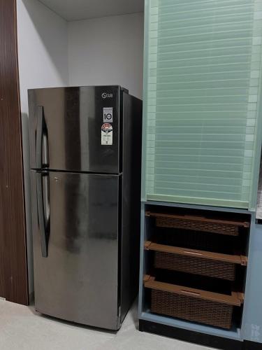 a stainless steel refrigerator sitting next to a window at 13th Floor 3BHK Flat with Mountain View in Bengaluru