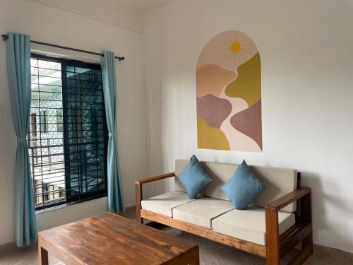 ein Wohnzimmer mit einer Couch und einem Tisch und einem Fenster in der Unterkunft 12 Monks - Backpacker Resort in Arambol