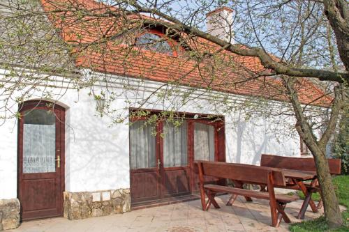 a wooden bench in front of a white building at Sörényes Udvarház in Pénzesgyőr