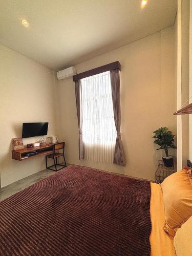 a bedroom with a bed and a window with a rug at BRICK HOUSE - Unique & Central in Selaparang