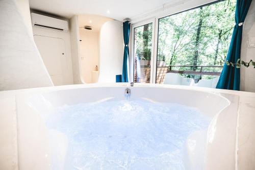 a bath tub in a room with a window at Oia Moon in Blaimont