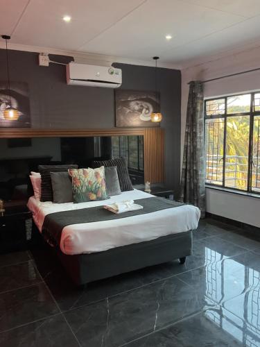 a bedroom with a large bed in a room at Bothabelo Bed and Breakfast in Phalaborwa