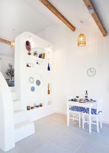 a white dining room with a table and stairs at Oia Moon in Blaimont