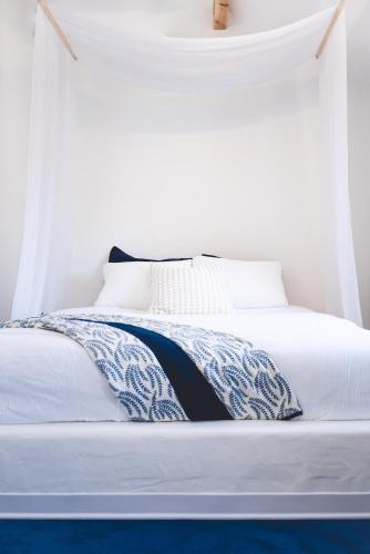 a white bed with a blue and white blanket on it at Oia Moon in Blaimont