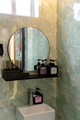 a bathroom with a mirror and a sink and a sink at CozyPosy Premier Apartment in Hanoi