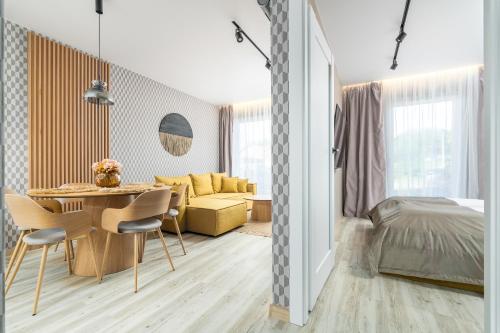 un salon avec une table à manger et une chambre dans l'établissement Apartament RIVIERA Let's Sea z Basenem by BALTIC CLUB, à Gąski
