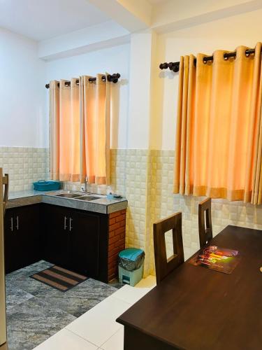 a kitchen with a sink and a wooden table at Unic Residence And Transit Hotel in Katunayake