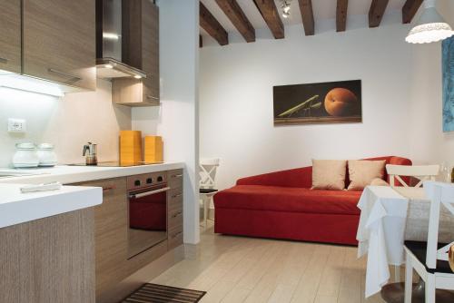 a kitchen and a living room with a red couch at Cà del Gambero in Venice