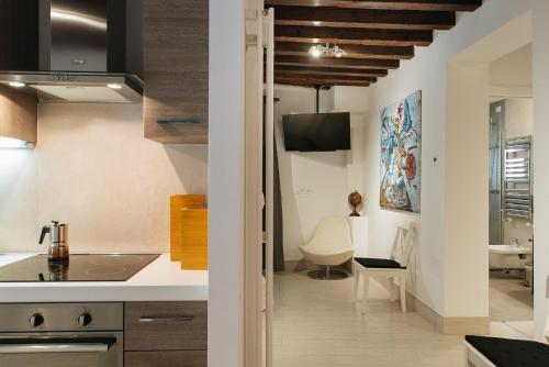 ヴェネツィアにあるCà del Gamberoの白いカウンターと木製の天井が備わるキッチン